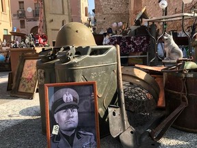 In this photo taken on Feb. 19, 2017 a picture of late dictator Benito Mussolini is displayed at an open air antiques market in Soave, neat Verona, Italy. Racist and anti-Semitic expressions have been growing more bold, widespread and violent in Italy. Anti-migrant rhetoric is playing an unprecedented role in shaping the campaign for the March 4 national elections, and many say that is worsening tensions and even encouraging violence.