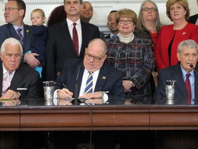 Maryland Gov. Larry Hogan signs a bill into law that enables women impregnated by rapists to end the parental rights of their attacker during a bill-signing ceremony on Tuesday, Feb. 13, 2018, in Annapolis, Md. Senate President Thomas V. Mike Miller is seated left of Hogan, and House Speaker Michael Busch is to the right. Sen. Brian Feldman and Del. Kathleen Dumais, the leading bill sponsors, are standing behind the governor.