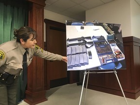 Deputy Lisa Jansen displays photos of weapons and ammo at a news conference in Los Angeles on Wednesday, Feb. 21, 2018. Authorities say they've thwarted a student's plot for a mass shooting at a Southern California high school. The Los Angeles County Sheriff's Department said Tuesday that a security guard at El Camino High School in Whittier overhead a "disgruntled student" threaten to open fire on the school on Friday, just two days after 17 people were gunned down at a Florida high school. Sheriff's spokeswoman Nicole Nishida tells The Associated Press that deputies discovered "multiple guns and ammunition" after searching the student's home..