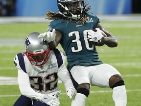 Philadelphia Eagles' Jay Ajayi, right, tries to get away from New England Patriots' Devin McCourty during the first half of the NFL Super Bowl 52 football game Sunday, Feb. 4, 2018, in Minneapolis.