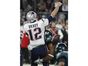 Philadelphia Eagles' Brandon Graham, center, strips the ball from New England Patriots quarterback Tom Brady during the second half of the NFL Super Bowl 52 football game Sunday, Feb. 4, 2018, in Minneapolis. The Eagles recovered the fumble.