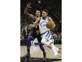 Golden State Warriors guard Stephen Curry, right, drives to the basket against Sacramento Kings guard George Hill during the first quarter of an NBA basketball game Friday, Feb. 2, 2018, in Sacramento, Calif.