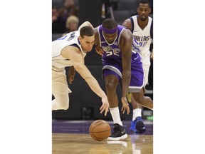 Dallas Mavericks forward Dwight Powell, left, and Sacramento Kings forward Zach Randolph scramble after the ball during the first quarter of an NBA basketball game Saturday, Feb. 3, 2018, in Sacramento, Calif.