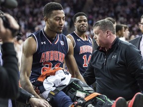 Auburn forward Anfernee McLemore (24) is carted off the court after an injury during the first half of the team's NCAA college basketball game against South Carolina on Saturday, Feb. 17, 2018, in Columbia, S.C. South Carolina defeated Auburn 84-75.