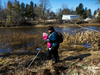 Victoria Brighton Thorpe, with her baby, searches the banks of the Grand River in Waldemar, Ontario for signs of three-year-old Kaden Young, who was swept away by flooding last week.