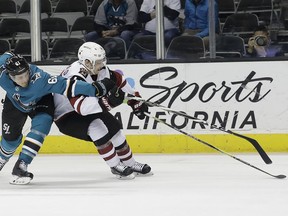 San Jose Sharks defenseman Justin Braun, left, and right wing Josh Archibald (45) reach for the puck during the first period of an NHL hockey game in San Jose, Calif., Tuesday, Feb. 13, 2018.