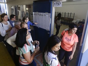 Voters stand at a polling station during general elections in San Jose, Costa Rica, Sunday, Feb. 4, 2018. Costa Ricans voted Sunday in a presidential race shaken by an international court ruling saying the country should let same-sex couples get married.