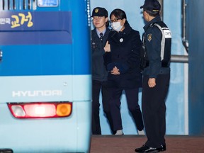 Choi Soon-sil (center), confidante of South Korea's former President Park Geun-hye, is escorted to a prison bus at the Seoul Central District Court in Seoul, South Korea, on Feb. 13, 2018. MUST CREDIT: Bloomberg photo by SeongJoon Cho.