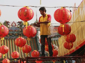 A Thai worker decorates lanterns for celebrations of Chinese New Year at the Leng Nuei Yee Chinese temple in Bangkok, Thailand, Wednesday, Feb. 14, 2018. Chinese New Year falls on Feb. 16 this year, marking the start of the Year of the Dog.