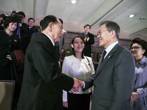 In this photo provided by South Korea Presidential Blue House, South Korean President Moon Jae-in, right, shakes hands with North Korea's nominal head of state Kim Yong Nam as Kim Yo Jong, center, North Korean leader Kim Jong Un's sister, watches after a performance of North Korea's Samjiyon Orchestra at National Theater in Seoul, South Korea, Sunday, Feb. 11, 2018.