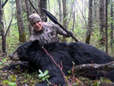 American Josh Bowmar, in an image taken from a video, poses with the spear and black bear he killed, which resulted in a public backlash.