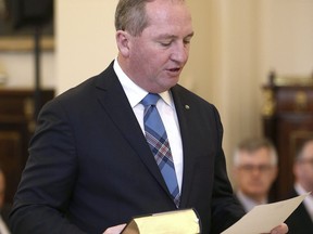 FILE - In this July 19, 2016, file photo, Barnaby Joyce takes the oath of office as he was sworn in as Deputy Prime Minister at Government House in Canberra, Australia.  Joyce is under mounting pressure to resign as party leader after newspapers revealed last week that he and a former staffer are expecting a baby.