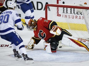 David Rittich of the Calgary Flames allows one of four third-period goals against the Tampa Bay Lightning in a 7-4 loss Thursday at the Scotiabank Saddledome. Watching the puck sneak past Rittich is Vladislav Namestnikov.