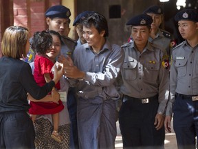 FILE - In this Feb. 1, 2018, file photo, Reuters journalist Kyaw Soe Oo, centre, is welcomed by his wife and daughter upon arrival at the court for their trial on the outskirts of Yangon, Myanmar.  Under Aung San Suu Kyi, Myanmar has aggressively pursued legal charges against dozens of journalists, along with other attempts to suppress and discredit the media.