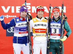 Akito Watabe, center, of Japan celebrates his victory in the Nordic combined World Cup event in Hakuba, central Japan, Saturday, Feb. 3, 2018. At left is second placed Norway's Jan Schmid while third placed Germany's Manuel Faisst is at right.