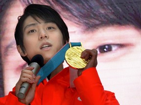 Japanese figure skater Yuzuru Hanyu shows off his gold medal he got in the Pyeongchang Olympics while speaking in Tokyo, Tuesday, Feb. 27, 2018, a day after returning home. After winning two Olympic gold medals, Hanyu has set his next realistic dream: Successful quadruple axel at competitions. Hanyu, who won gold in the Pyeongchang Games to become the first man to repeat as Olympic champion in 66 years,said Tuesday that he hoped to achieve the quadruple and half jump that nobody has successfully performed at a competition.