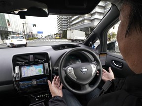 In this Wednesday, Feb. 21, 2018, photo, a Nissan Motor Co. staff member gets his hands off of the steering wheel of its Easy Ride robo-vehicle during a test ride on a course in Yokohama, near Tokyo. Starting next month, Nissan is testing on regular roads what it calls "a robo-vehicle mobility service." Called Easy Ride, it uses a cell-phone app to book semi-autonomous driven rides.