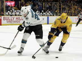 Nashville Predators right wing Craig Smith (15) takes the puck from San Jose Sharks right wing Barclay Goodrow (23) in the first period of an NHL hockey game Thursday, Feb. 22, 2018, in Nashville, Tenn.