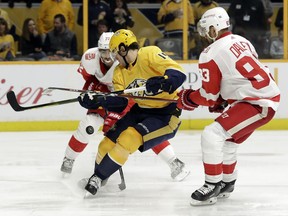Nashville Predators right wing Craig Smith (15) battles Detroit Red Wings left wing Andreas Athanasiou (72) and defenseman Trevor Daley (83) for the puck in the second period of an NHL hockey game Saturday, Feb. 17, 2018, in Nashville, Tenn.