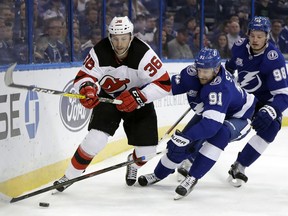 New Jersey Devils' Nick Lappin (36) and Tampa Bay Lightning center Steven Stamkos (91) chase a loose puck during the first period of an NHL hockey game Saturday, Feb. 17, 2018, in Tampa, Fla. Trailing the play is Lightning's defenseman Mikhail Sergachev (98).