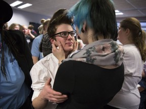 In this Dec. 4, 2014 file photo, Elliott Kunerth, 17, a transgender male high school student in Mankato, hugs his girlfriend, Kelsi Pettit, 17, after the Minnesota State High School League board voted to pass the Model Gender Identity Participation in MSHSL Activities Policy in Brooklyn Park, Minn.