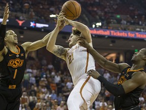 Oklahoma State guard Kendall Smith (1) commits a foul on Texas forward Dylan Osetkowski (21) during an NCAA college basketball game in Austin, Texas, on Saturday, Feb. 24, 2018.