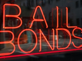 FILE - This July 7, 2015, file photo, shows a sign advertising a bail bonds business in the Brooklyn borough of New York. A new Texas nonprofit promoting crime victims' rights is opposing bipartisan efforts to end cash bail systems that have gained traction around the country - hitting back at one of the few issues that unified advocates on both the right and left. Kicking off Thursday, Feb. 15, 2018, the Texas Alliance for Safe Communities wants to strengthen public safety and curb violent crime.