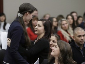 CORRECTS FROM CONVICTED TO SENTENCED - FILE - In this Jan. 24, 2018, file photo, former gymnast Rachael Denhollander, left, is hugged by Kaylee Lorincz after giving her victim impact statement during the seventh day of Larry Nassar's sentencing hearing in Lansing, Mich. Nassar was sentenced to decades in prison for sexually assaulting young athletes for years under the guise of medical treatment.