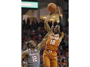 Texas' Kerwin Roach (12) shoots the ball over Texas Tech's Keenan Evans (12) during the first half of an NCAA college basketball game Wednesday, Jan. 31, 2018, in Lubbock, Texas.