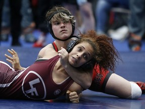 In this Friday, Feb. 16, 2018 photo, Euless Trinity's Mack Beggs, top, wrestles Lewisville's Elyse Nelson in the second round of the 110-pound girls division during the 6A Region II wrestling meet at Allen High School in Allen, Texas, Beggs, a senior from Euless Trinity High School near Dallas is transgender and in the process of transitioning from female to male.
