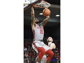 Houston forward Devin Davis, left, dunks as East Carolina forward Dimitri Spasojevic, right, watches during the first half of an NCAA college basketball game, Sunday, Feb. 25, 2018, in Houston.