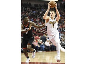 Denver Nuggets center Nikola Jokic, right, drives to the basket as Houston Rockets center Clint Capela defends during the first half of an NBA basketball game, Friday, Feb. 9, 2018, in Houston.