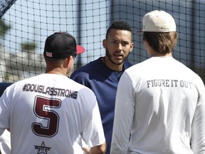 Houston Astros shortstop Carlos Correa chats with Douglas Stoneman High School's baseball head coach Todd Fitz-Gerald, left, and his son, Hunter Fitz-Gerald, right, during baseball spring training in West Palm Beach, Fla., Friday, Feb. 23, 2018.