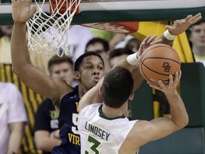 West Virginia forward Sagaba Konate (50) guards against a shot attempt by Baylor guard Jake Lindsey (3) during the first half of an NCAA college basketball game Tuesday, Feb. 20, 2018, in Waco, Texas.