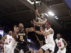 Wichita State forward Markis McDuffie (32) goes up for a shot over forward Darral Willis Jr. (21) and Southern Methodist guard William Douglas (3) in the first half of an NCAA college basketball game Saturday, Feb. 24, 2018, in Dallas.