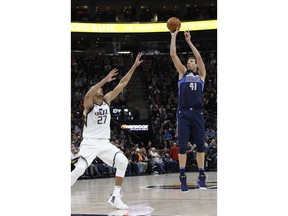 Dallas Mavericks' Dirk Nowitzki (41) shoots as Utah Jazz's Rudy Gobert (27) defends in the first half of an NBA basketball game on Saturday, Feb. 24, 2018, in Salt Lake City.