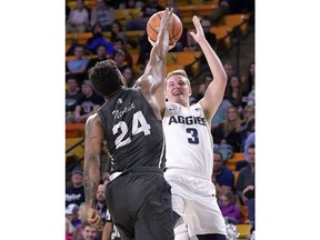 Utah State guard Sam Merrill (3) shoots as Nevada guard Jordan Caroline (24) defends during an NCAA college basketball game Saturday, Feb. 17, 2018, in Logan, Utah.