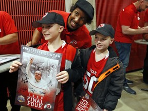 Andre Miller, center, a former Utah player poses for photos with young fans before an NCAA college basketball game between California and Utah on Saturday, Feb. 10, 2018, in Salt Lake City. Players from the 1998 NCAA championship game Utah team were on hand for a halftime ceremony.