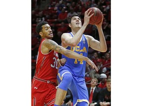 UCLA forward Gyorgy Goloman (14) goes to the basket as Utah guard Gabe Bealer (30) defends during the first half of an NCAA college basketball game Thursday, Feb. 22, 2018, in Salt Lake City.
