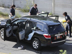 FILE - In this June 6, 2017 file photo, crime scene investigators inspect the scene of a fatal shooting in the Salt Lake City suburb of Sandy, Utah. Police documents show a Utah man who killed his ex-girlfriend and her 6-year-old son when he opened fire on a car full of children in June had told several people he was fixated on killing her.