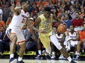 Georgia Tech's Moses Wright (12) drives past Virginia's Isaiah Wilkins (21) during the first half of an NCAA college basketball game Wednesday, Feb. 21, 2018, in Charlottesville, Va.