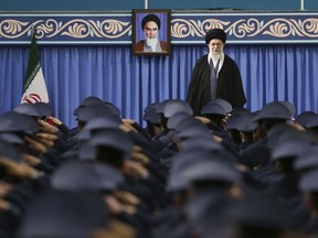 In this picture released by official website of the office of the Iranian supreme leader, Supreme Leader Ayatollah Ali Khamenei stands as army air force and air defense staff salute at the start of their meeting in Tehran, Iran, Thursday, Feb. 8, 2018. A portrait of the late revolutionary founder Ayatollah Khomeini hangs in background. (Office of the Iranian Supreme Leader via AP)