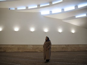 In this Wednesday, Feb. 7, 2018, photo, Catherine Spiridonoff, co-architect of the Vali-e-Asr mosque walks on its second floor and women's prayer hall, in Tehran, Iran.  The architects behind the Vali-e-Asr mosque dispensed with the traditional rounded domes and towering minarets, instead opting for a modern design of undulating waves of gray stone and concrete, which they say complements the surrounding architecture and evokes the austerity of early Islam.