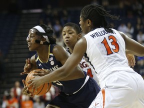 Notre Dame guard Jackie Young (5) is pressured by Virginia guard Jocelyn Willoughby (13) and Virginia guard Dominique Toussaint, center back, during the first half of an NCAA college basketball game in Charlottesville, Va., Thursday, Feb. 15, 2018.