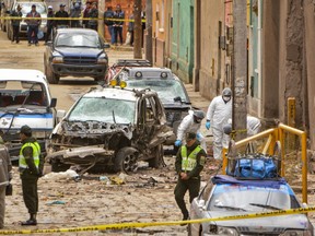 Police inspect the site of an explosion that killed four people, in Oruro, Bolivia, Wednesday, Feb. 14, 2018. Bolivia's Defense Minister Javier Zabaleta says an explosive was used in a blast that went off Tuesday night, the second deadly explosion to hit the city of Oruro during Carnival celebrations.