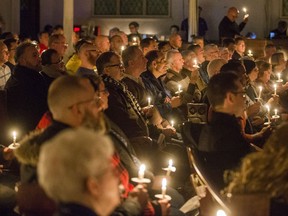 Community members and dignitaries light candles during a vigil hosted by the Metropolitan Community Church of Toronto, in Toronto on Sunday, February 4, 2018. A downtown Toronto neighbourhood came together to mourn the deaths of several men in the LGBTQ community at the hands of an alleged serial killer.THE CANADIAN PRESS/Christopher Katsarov