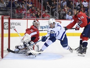 Tampa Bay Lightning center Brayden Point (21) scores a goal past Washington Capitals goaltender Braden Holtby (70) and defenseman John Carlson (74) during the first period of an NHL hockey game, Tuesday, Feb. 20, 2018, in Washington.