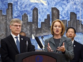 Seattle City Attorney Pete Holmes, left, looks on as Mayor Jenny Durkan speaks at a news conference announcing plans for the city to move to vacate misdemeanor marijuana possession convictions, Thursday, Feb. 8, 2018, in Seattle. City Council member Bruce Harrell looks on at right. Five years after Washington state legalized marijuana, Seattle officials say they're moving to automatically clear past misdemeanor convictions for pot possession. San Francisco recently took the same step.