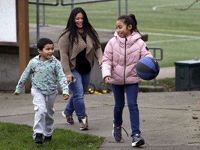 In this Thursday, Feb. 15, 2018, photo, Lara Mae Chollette, a coach of youth soccer and basketball, follows her daughter Linda, 10, right, and son Jaylen, 7, at a playground in Seattle. Horrific cases and allegations of predatory crimes against youth in gymnastics, swimming and football, among other sports, have jolted many parents who say they believe sports can be an important part of their child's development. Some now feel compelled to take a more cautious approach in monitoring adult interactions, as advancement beyond pee-wee leagues become increasingly coach-driven.