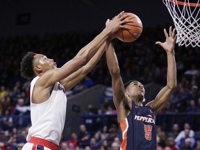 Pepperdine guard Jade' Smith (5) and Gonzaga forward Johnathan Williams go after a rebound during the first half of an NCAA college basketball game in Spokane, Wash., Saturday, Feb. 17, 2018.